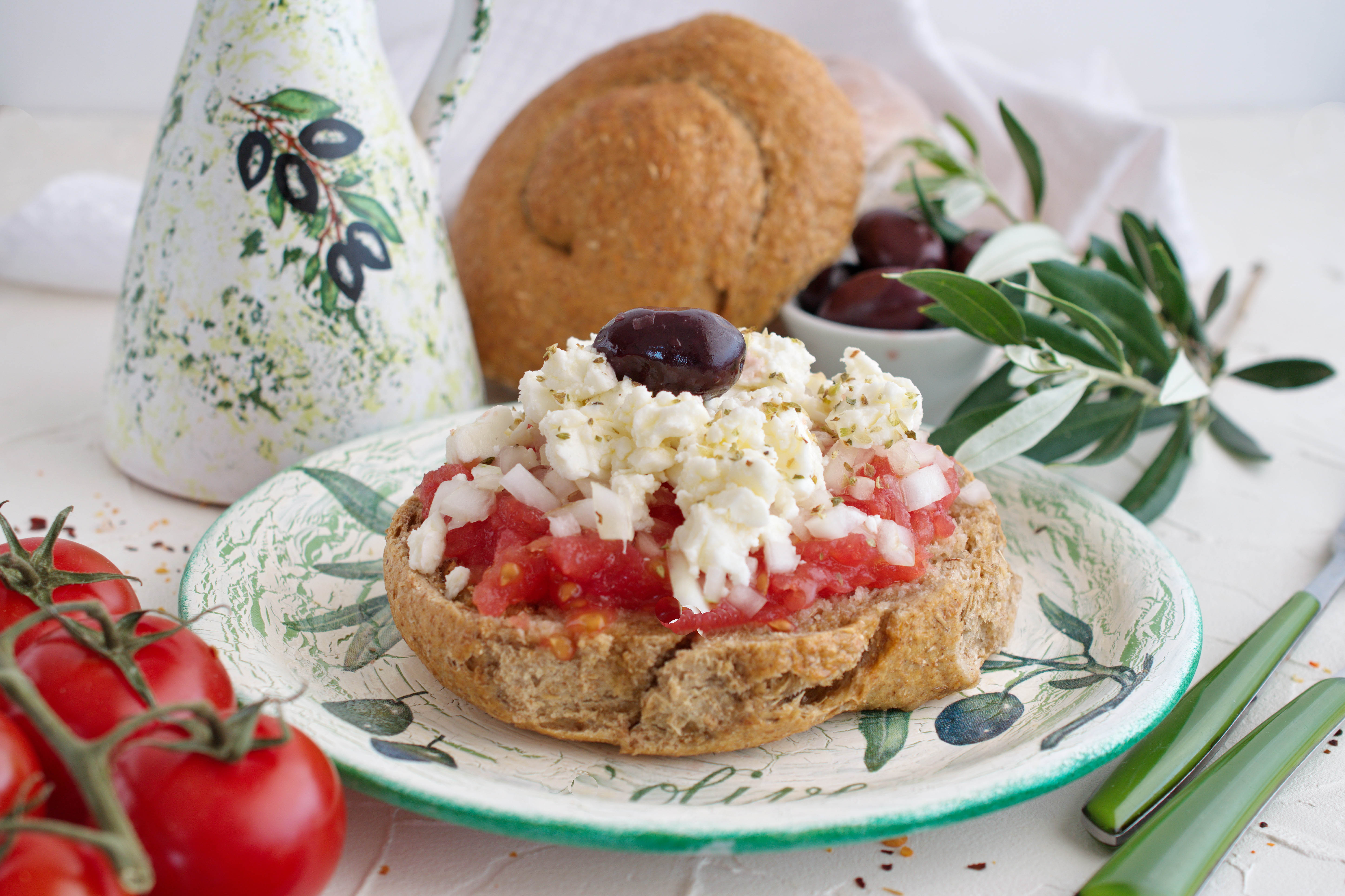 
Traditional Cretan dakos with tomato, feta cheese and olive oil on rustic plate