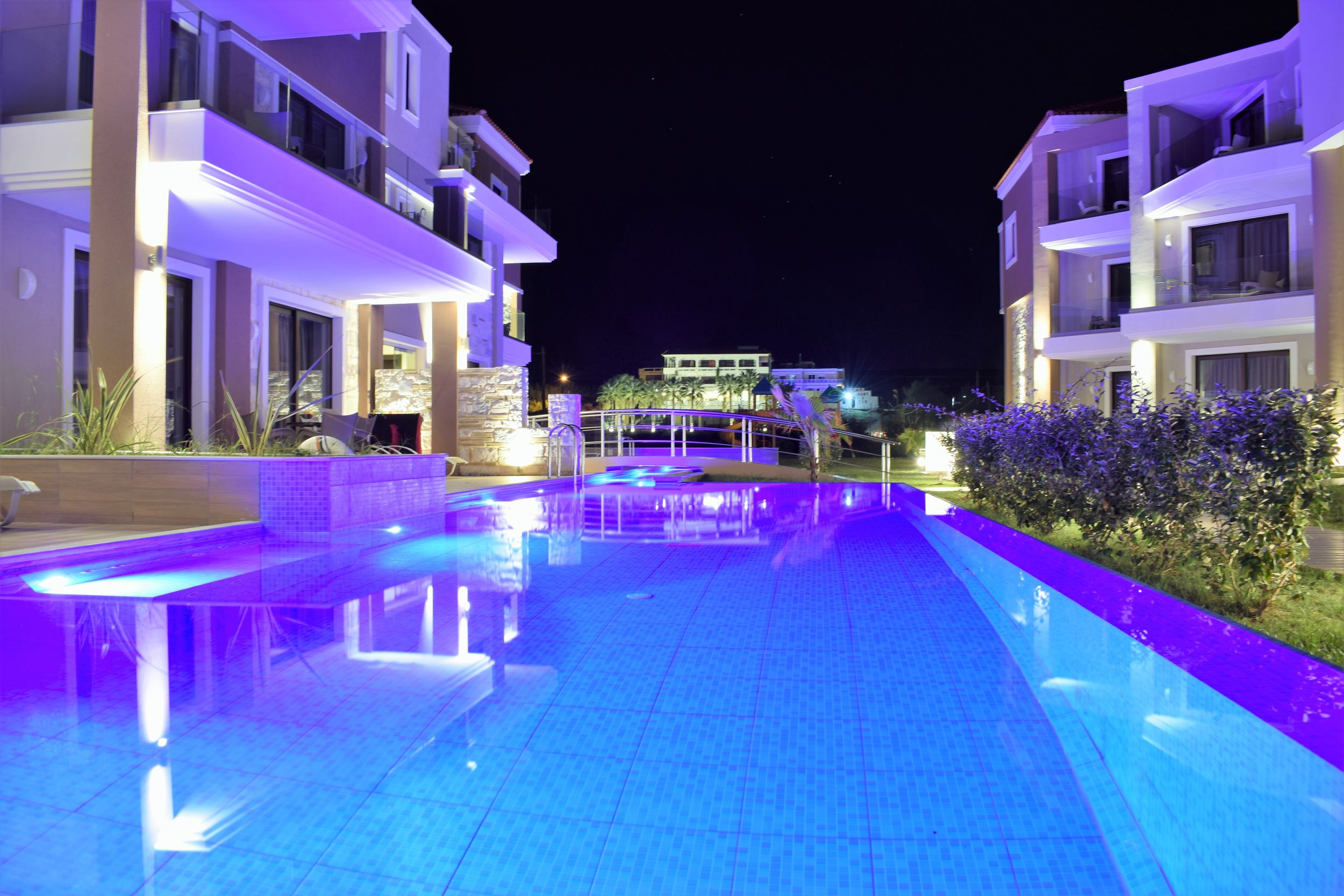 
Night view of the private pool reflecting the illuminated apartment buildings at Hike Hotel
