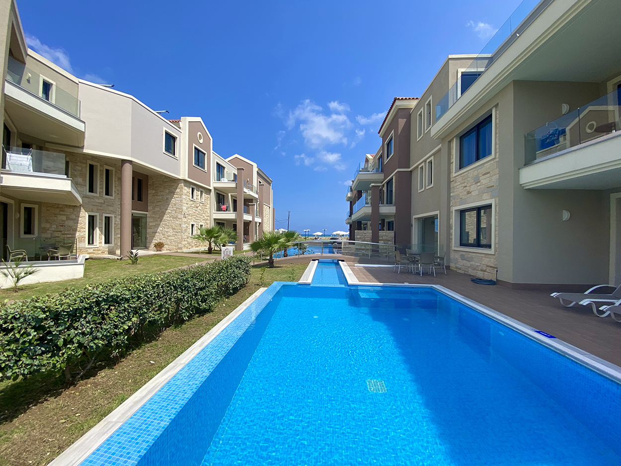 
Modern apartment complex in Mike Hotel with shared swimming pool and sea view pathway in the distance